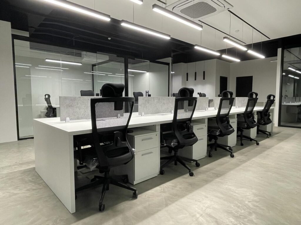 Modern office fit-out for Al Diyar Al Dimashqia Trading featuring custom workstations, meeting room, and TV wall cladding with premium architectural finishes.