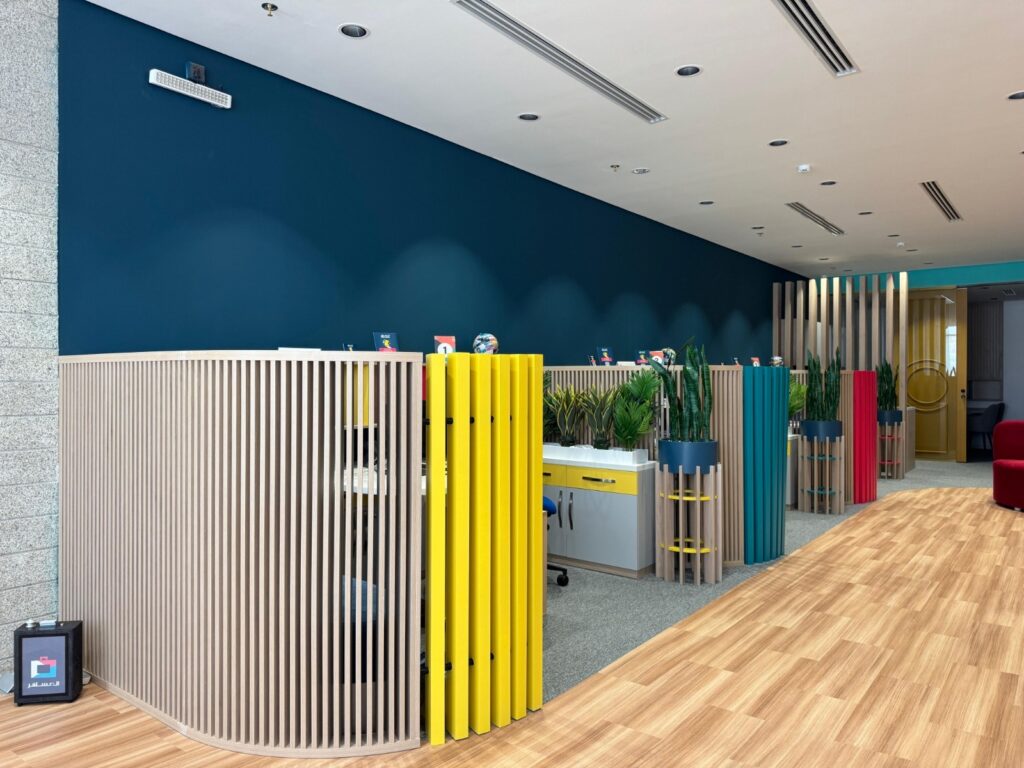 Premium office fit-out for Almosafer featuring custom wood joinery, reception area, meeting room, and branded wall cladding with integrated logo.